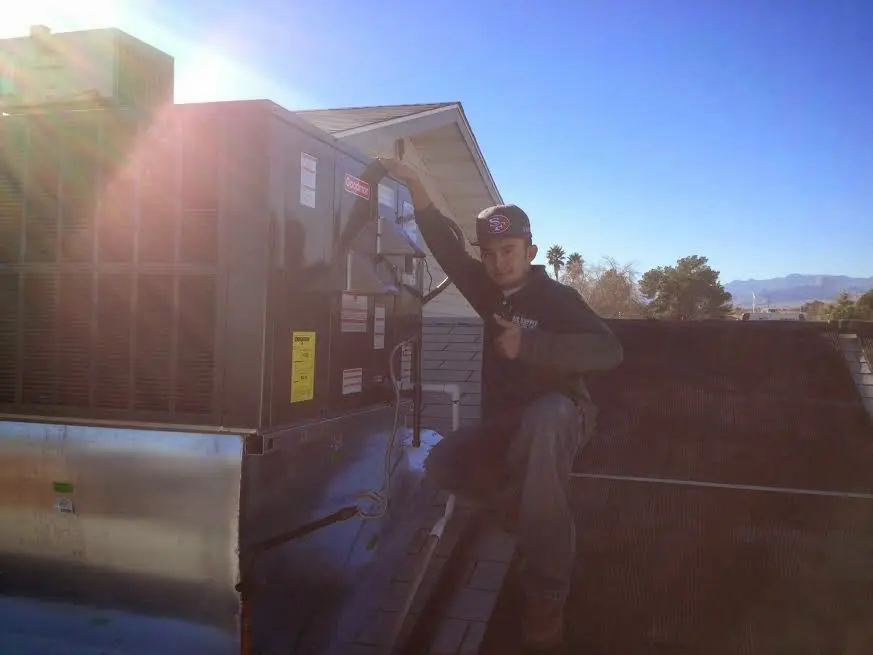 HVAC technician performing Heat Pump Repair on a rooftop unit in Sherwood